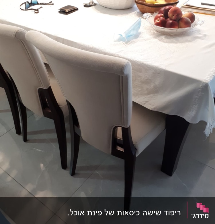 כיסאות מרופדים ליד שולחן עם מפה לבנה